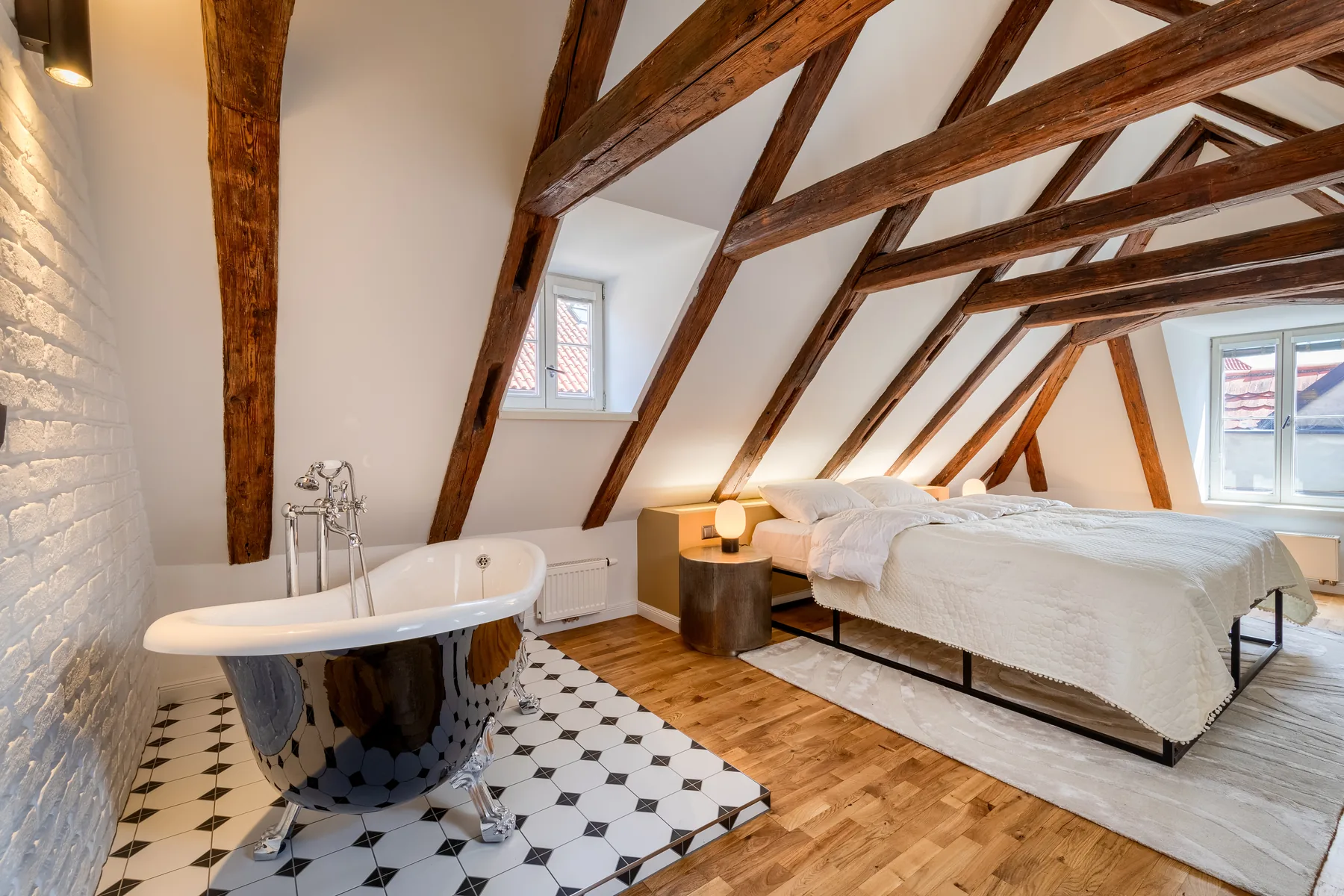 Attic suite at Domus Balthasar with exposed timber beams and a freestanding bath